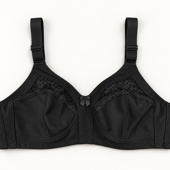Black non-padded bra with seamed cups, curved floral-lace inserts, wide adjustable straps and a small centre bow.