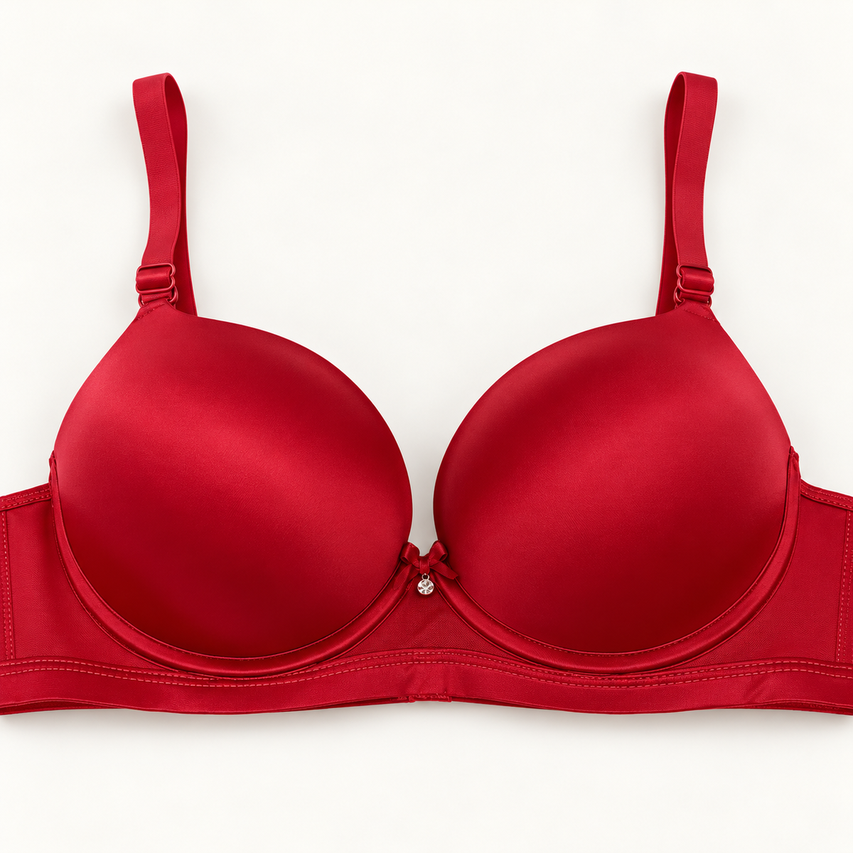 Red push-up bra with smooth cups, a plain stitched band and adjustable straps. Finished with a small centre bow and charm.