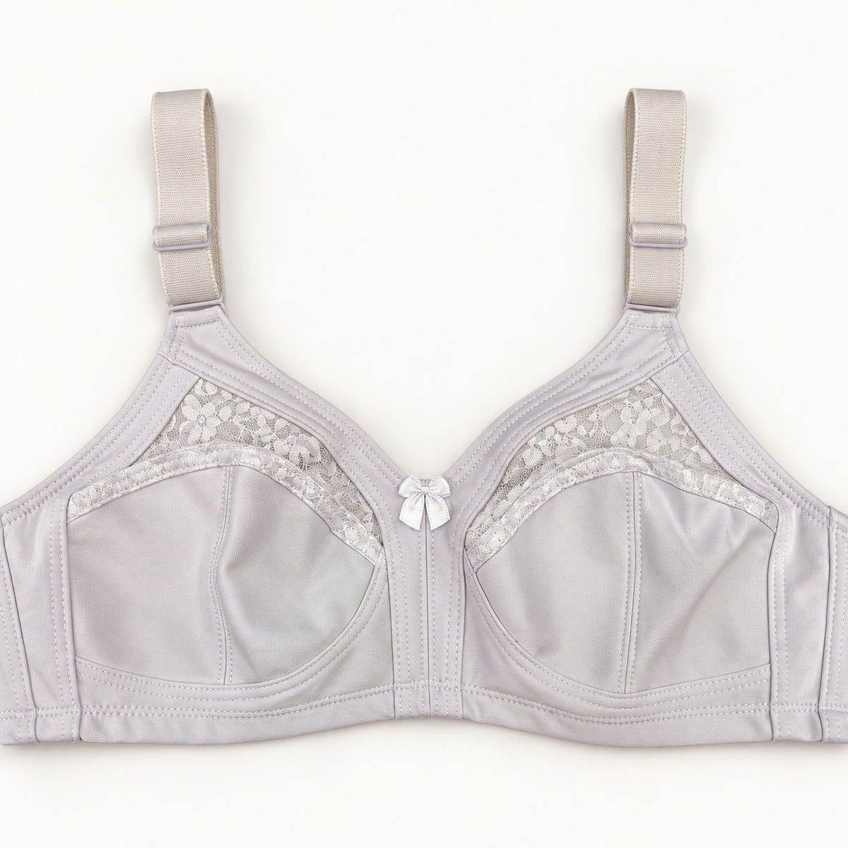 White non-padded bra with seamed cups and curved floral-lace inserts. Wide adjustable straps and a small centre bow complete the design.